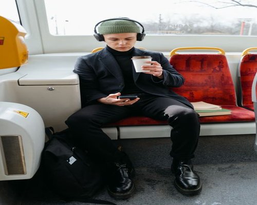 Person holding a smartphone while sitting on a public bus